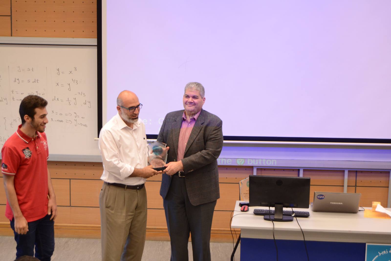 Ahmed Maarouf receiving the Professor of Excellence Award trophy at the ceremony